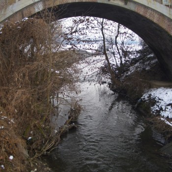 Flowing river underneath a bridge